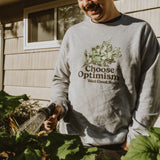 a guy watering plants with our choose optimism garden wear