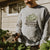 a guy watering plants with our choose optimism garden wear
