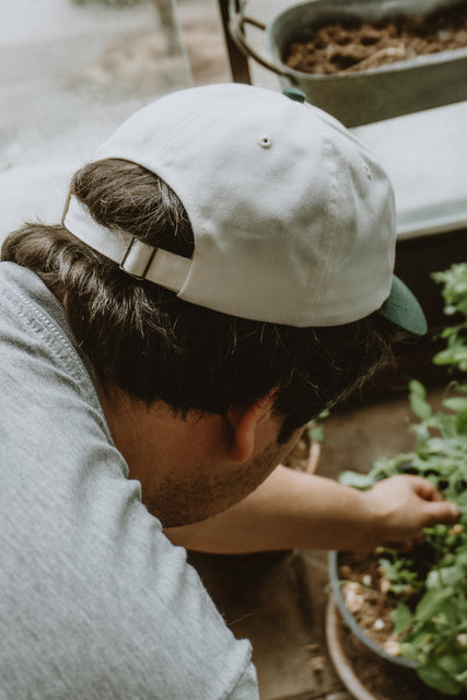 West Coast Seeds - A man wearing an Organic Cotton Hat  in a garden, made canada