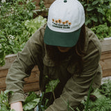 West Coast Seeds - A woman wearing an Organic Cotton Hat  in a garden, made canada
