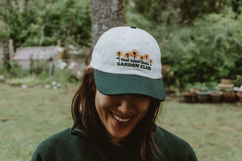 West Coast Seeds - A woman wearing an Organic Cotton Hat  in a garden, made canada