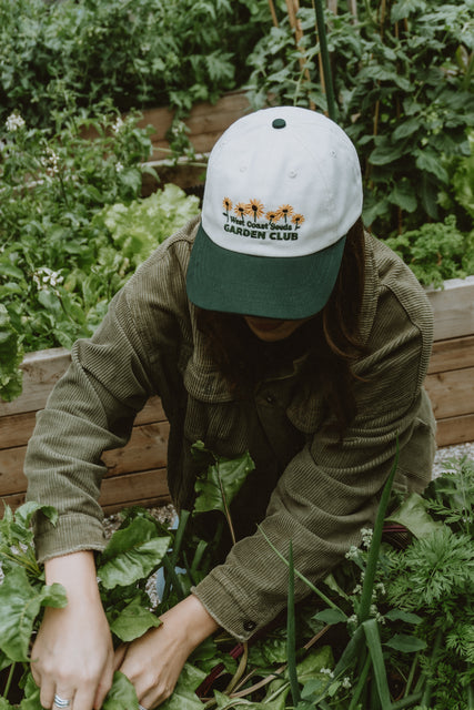 West Coast Seeds - A woman wearing an Organic Cotton Hat  in a garden, made canada