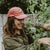 West Coast Seeds - A Woman wearing an Organic Cotton Hat  in a garden, made in canada
